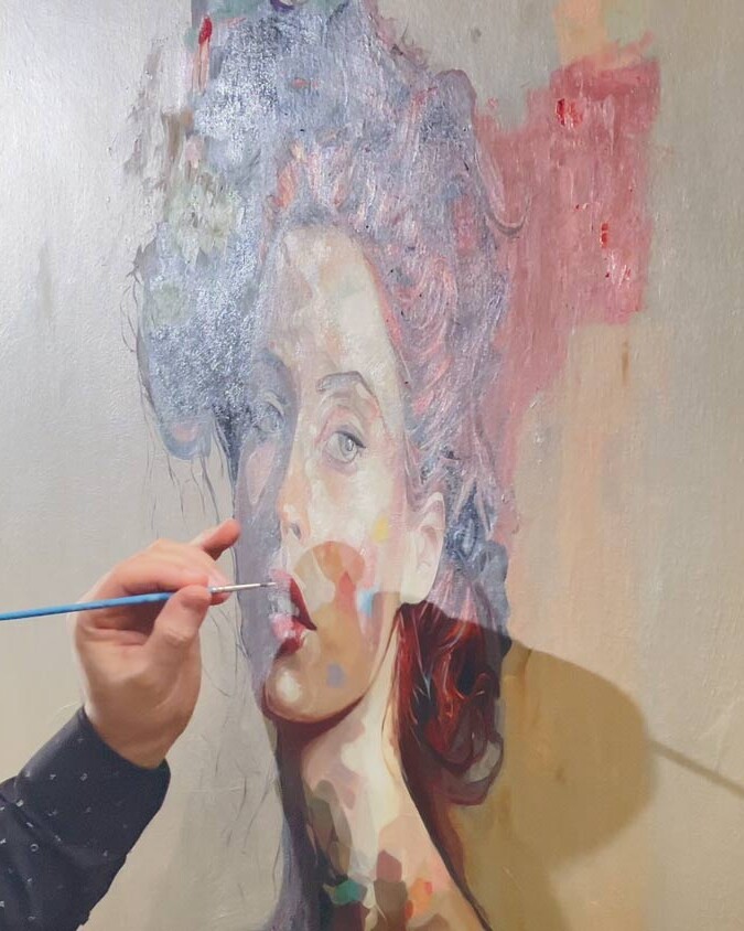 Artist Alex Righetto at work on 'Mona Lisa's Daughter', skillfully applying brushstrokes to the canvas.